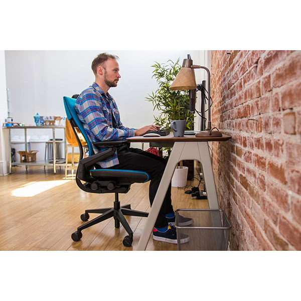فردی به حالت استاندارد روی یک صندلی ارگونومیک نشسته و درحال کار با سیستم است